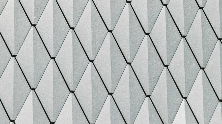 Trapesformet takvindu på en enebolig i Mechernich, kledd med små PREFA takrombe i P.10 antrasitt. Taket er dekket med PREFA takhingel DS.19 i samme farge. Den høykvalitets aluminiumsbekledningen sørger for værbestandighet og et moderne, estetisk utseende.