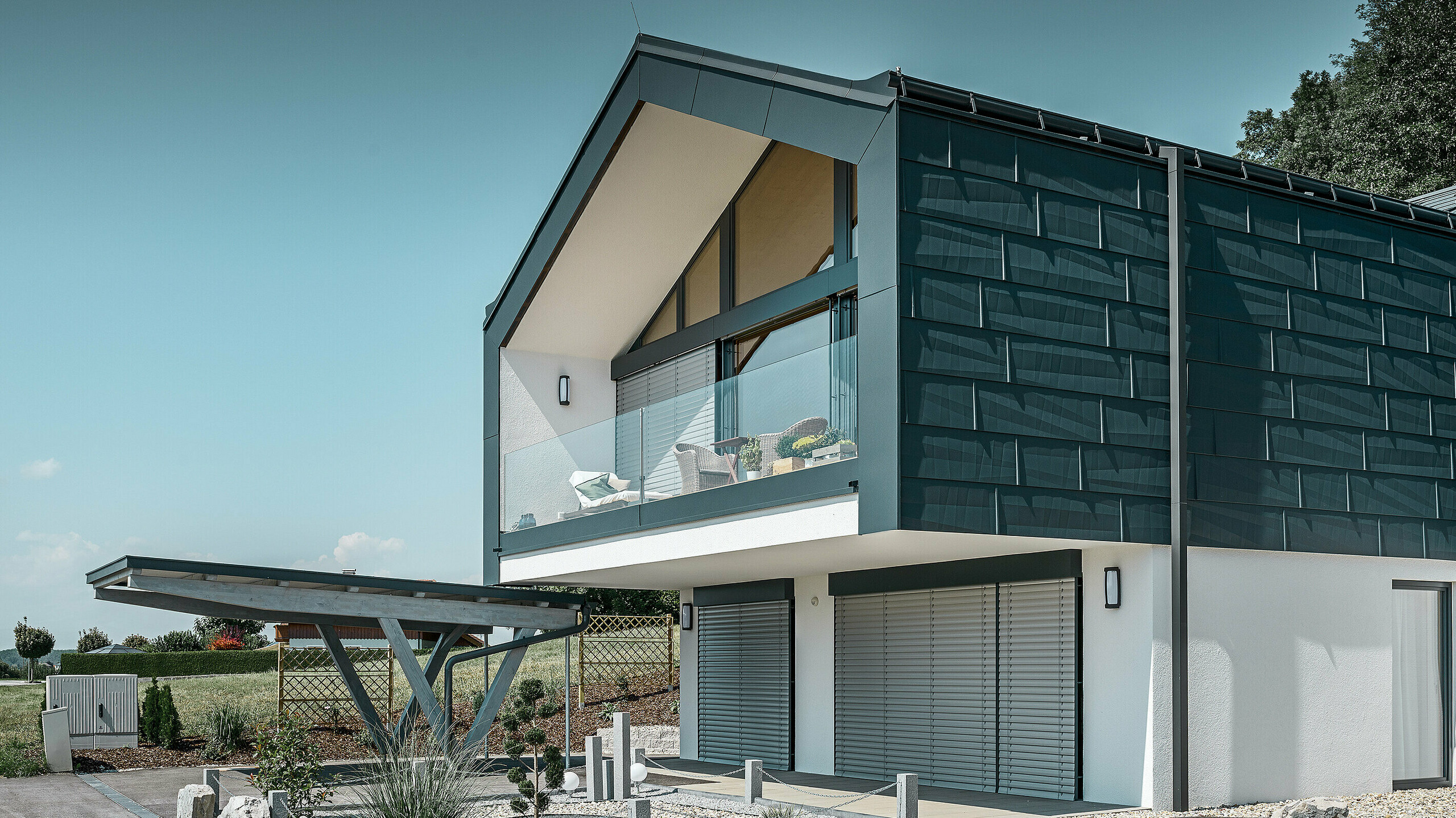 Fasadekledning i øverste etasje med PREFA fasadepanel FX.12 i P.10 antrasitt. Det robuste PREFA-firkantrøret fungerer som avløpsrør.