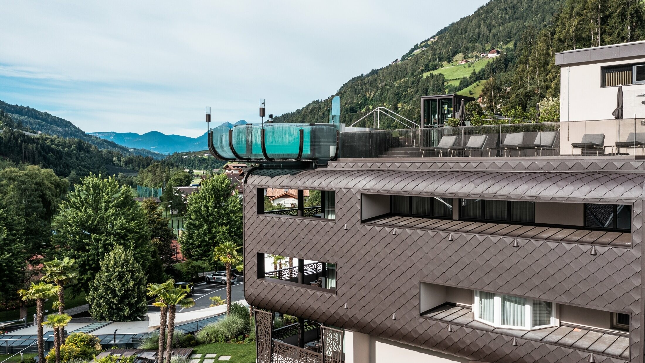 Neben den PREFA-Fassadenschindeln sticht der beeindruckende Pool des Hotelbereichs hervor.