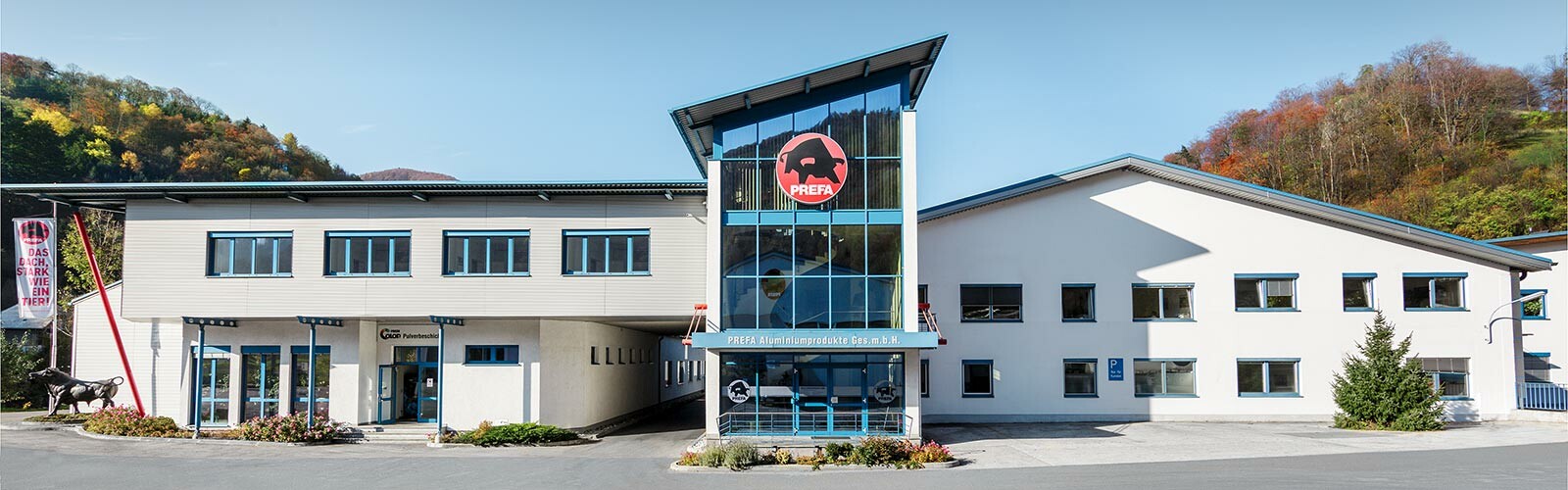 PREFA firmabygning med hvit fasade og blå vinduer