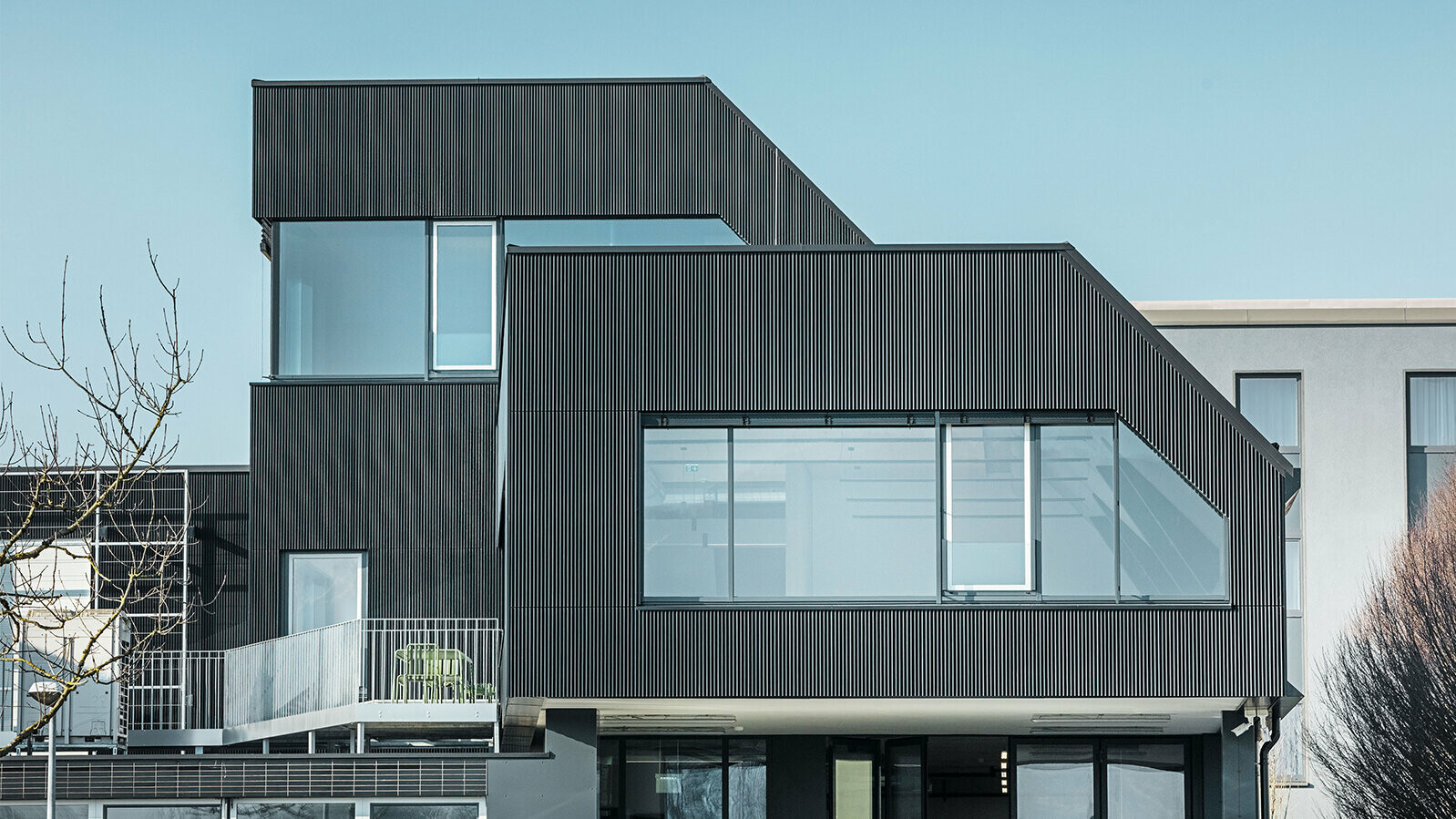 Amann-kaffebygg sett fra siden på en solrik dag. Det ble brukt en riflet profil i fargen svart for å beskytte bygget.