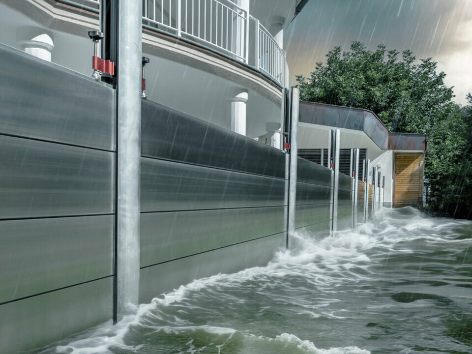 Nærbilde av PREFAs flomvern i aluminium, som alltid tåler flomkatastrofer og beskytter eneboligen i bakgrunnen.