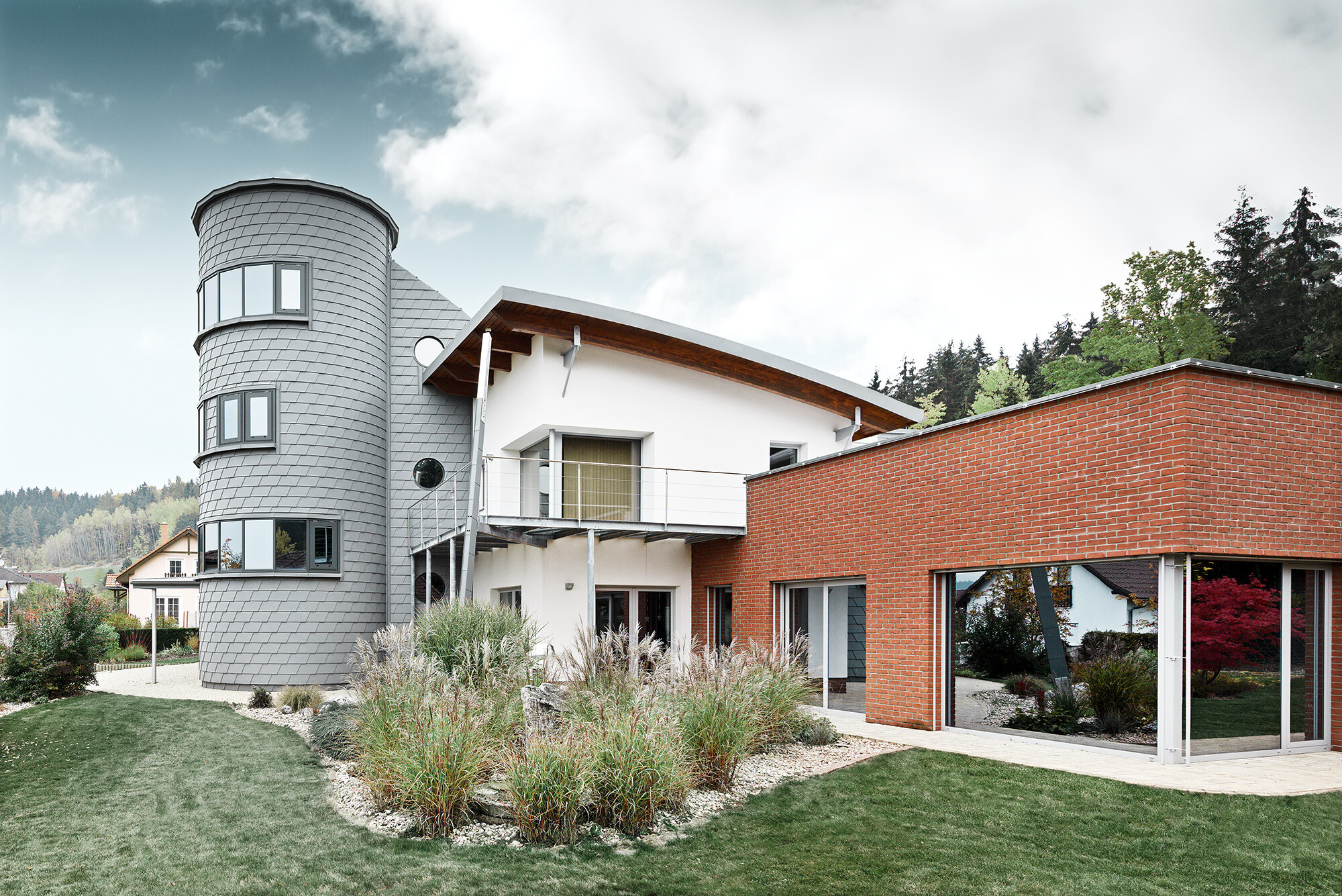 Enebolig med tårnbygg, det runde tårnet er kledd med PREFA veggshingel i patinagrått 