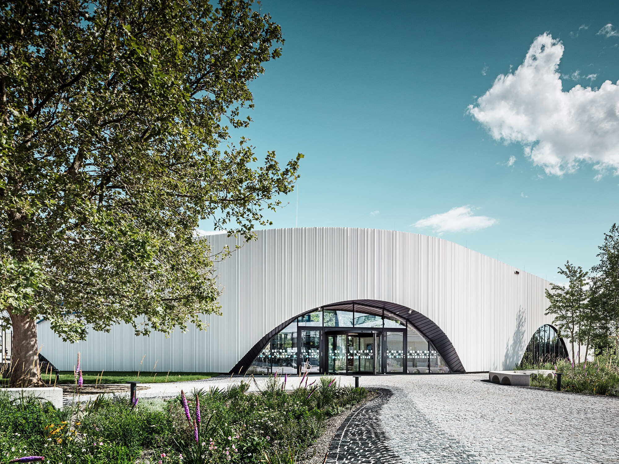 Normalvisning av Restaurant Walters med ett av sine rundbuevinduer, i en grønn og frodig omgivelse.