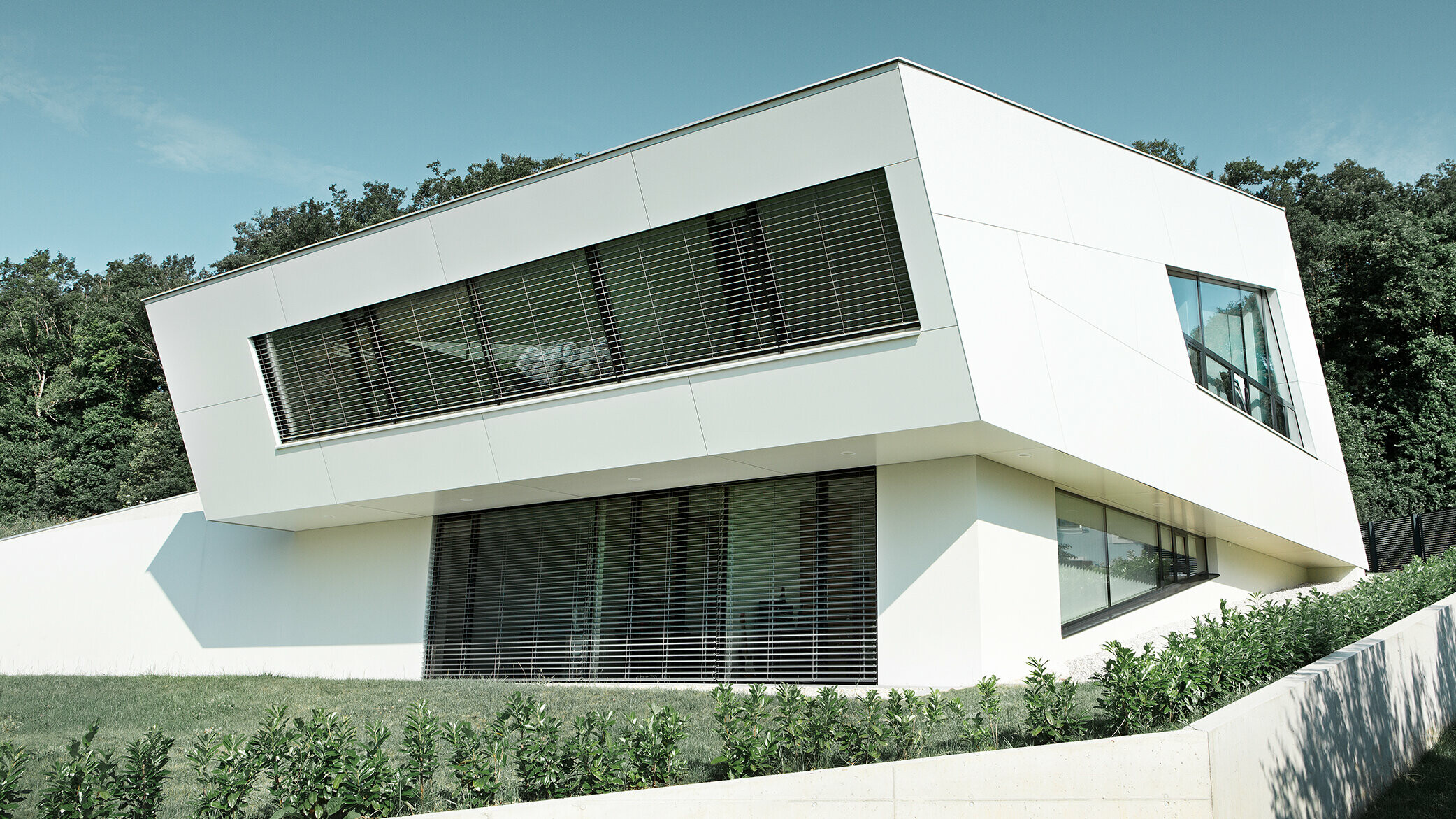 Meget moderne enebolig med hvit PREFA komposittplatefasade og store vinduer