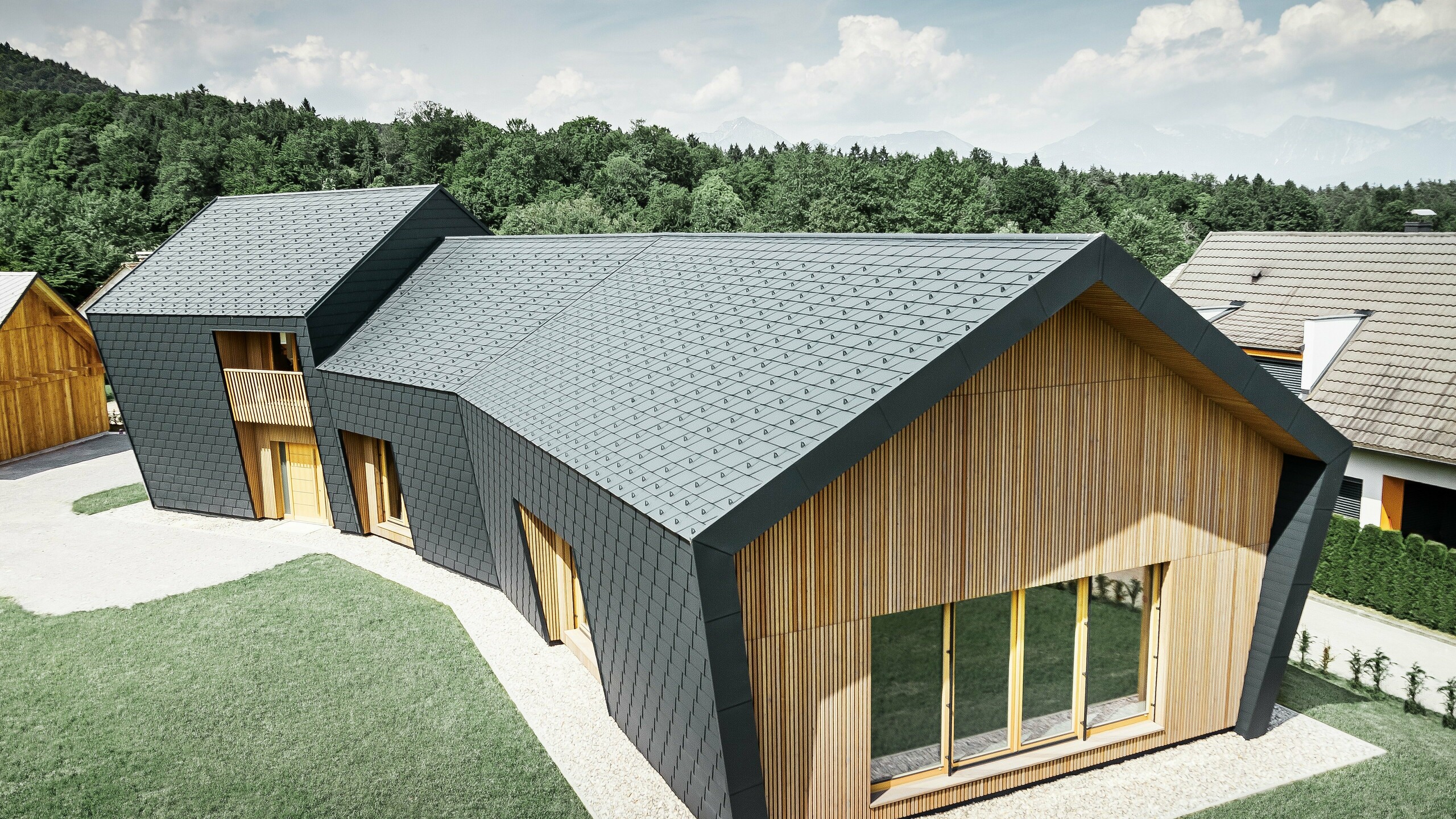 Store tak- og fasadearealer, dekket med takshingel DS.19 i P.10 antrasitt, på endesiden ble fasaden kledd med tre