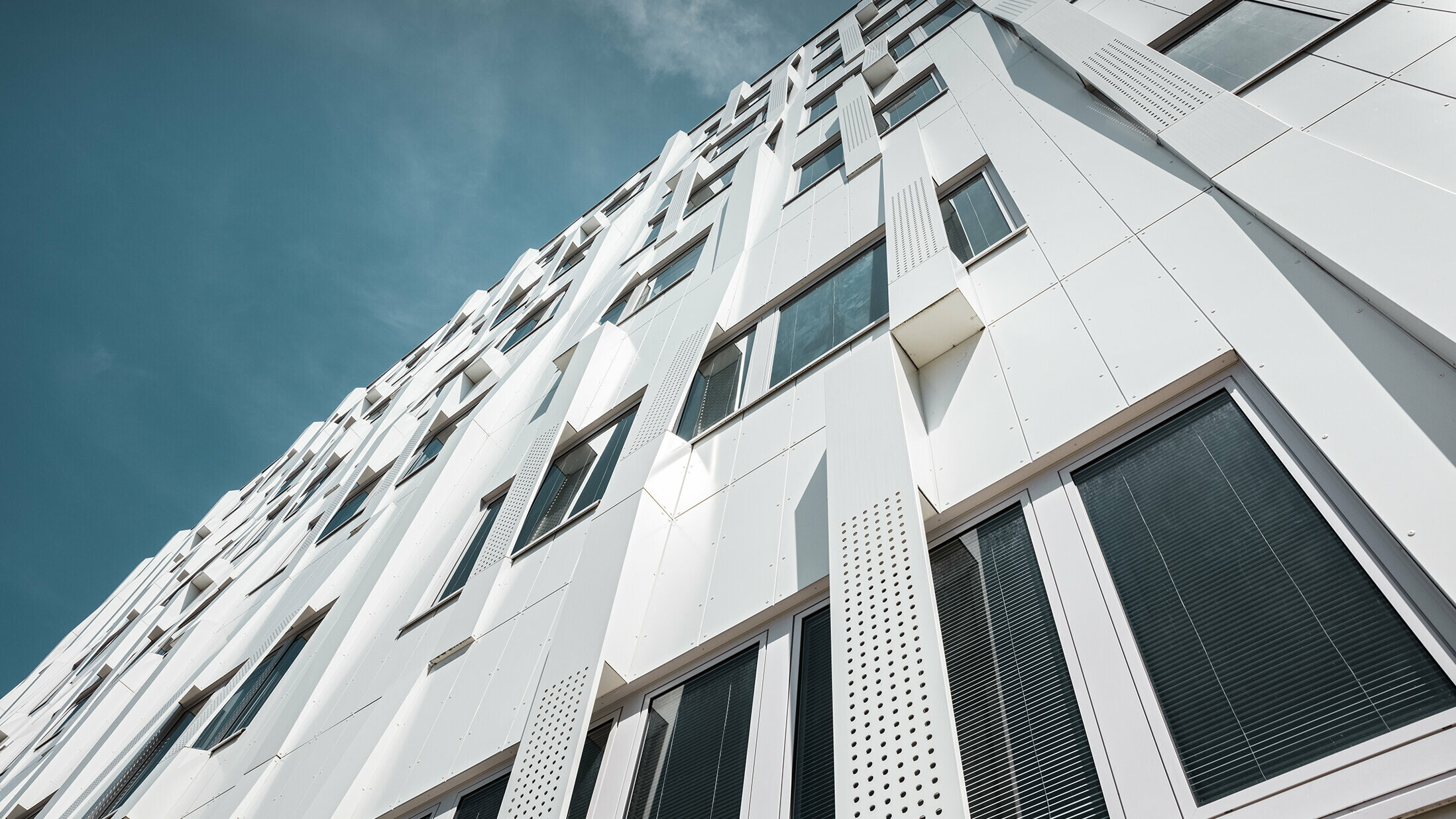 Spesiell 3D-fasade med hullede aluminiumskomposittplate-kassetter og normale PREFA komposittplater i ren hvit, kassettfasade PREFA