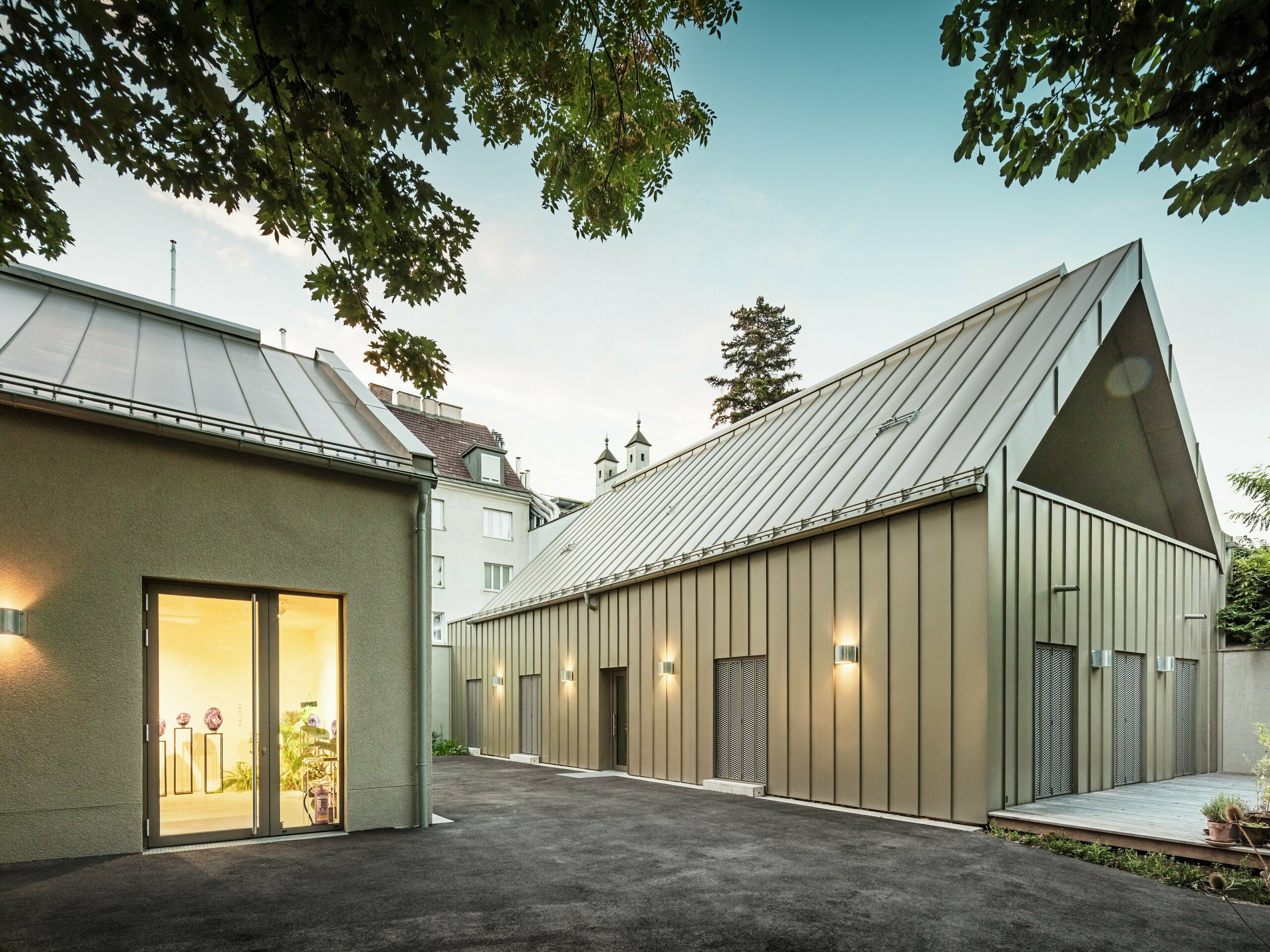 Seitenansicht des Studio Comploj in Wien mit PREFALZ-Aluminiumfassade in P.10 Prefabronze. Das moderne Ensemble aus Glaskunst, Galerie und Wohnraum vereint Handwerkskunst und Architektur.