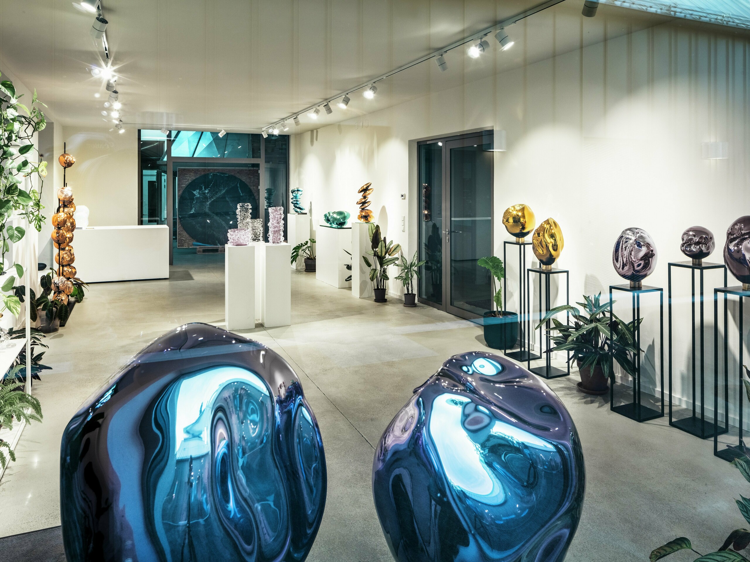 Ein Blick ins Innere des Studio Comploj in Wien mit einer Ausstellung handgefertigter Glasobjekte. Der moderne Galerieraum vereint Kunst, Design und Handwerkskunst in einem eleganten Ambiente.