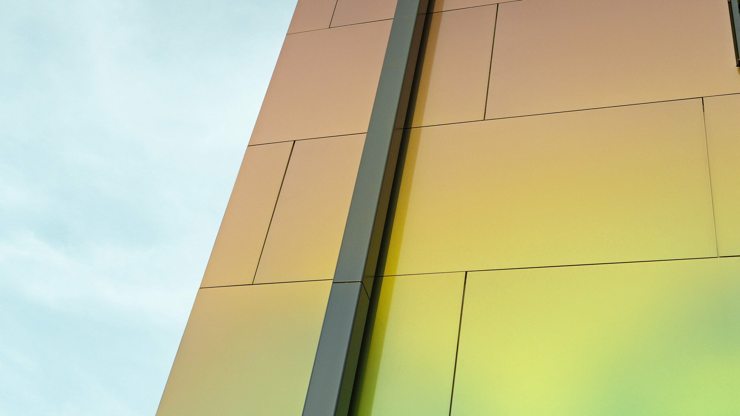 Huskant på en moderne enebolig med det moderne nedløpsrøret PREFA firkantrør for drenering av det flate taket. Fasaden er kledd med aluminiums-komposittplate i den glitrende fargen «spring lake».