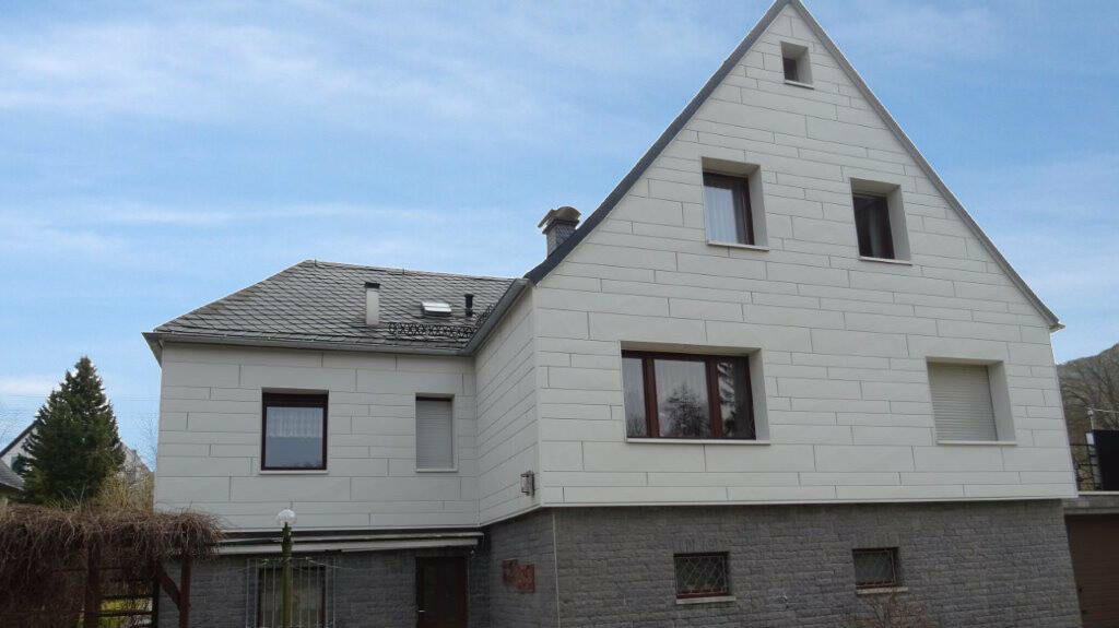 Fassadensanierung einer Putzfassade mit PREFA Sidings.X horizontal verlegt in Weiß mit grauem Klinker.