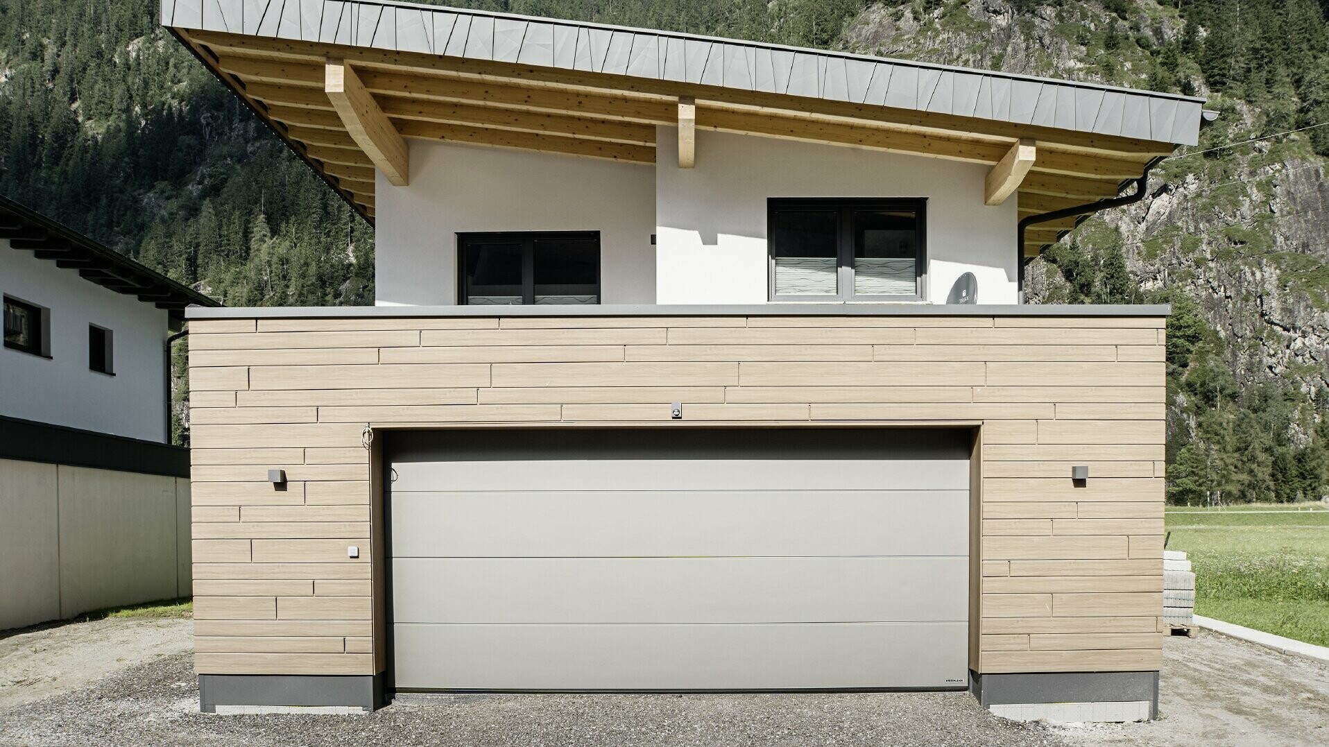 Moderne, ny bygning med pulttak og individuell vindski-metallkledning, garasje med flatt tak og aluminiumsfasade i brun valnøtt fra PREFA. Sidings ble lagt horisontalt og med ulike byggebredder.