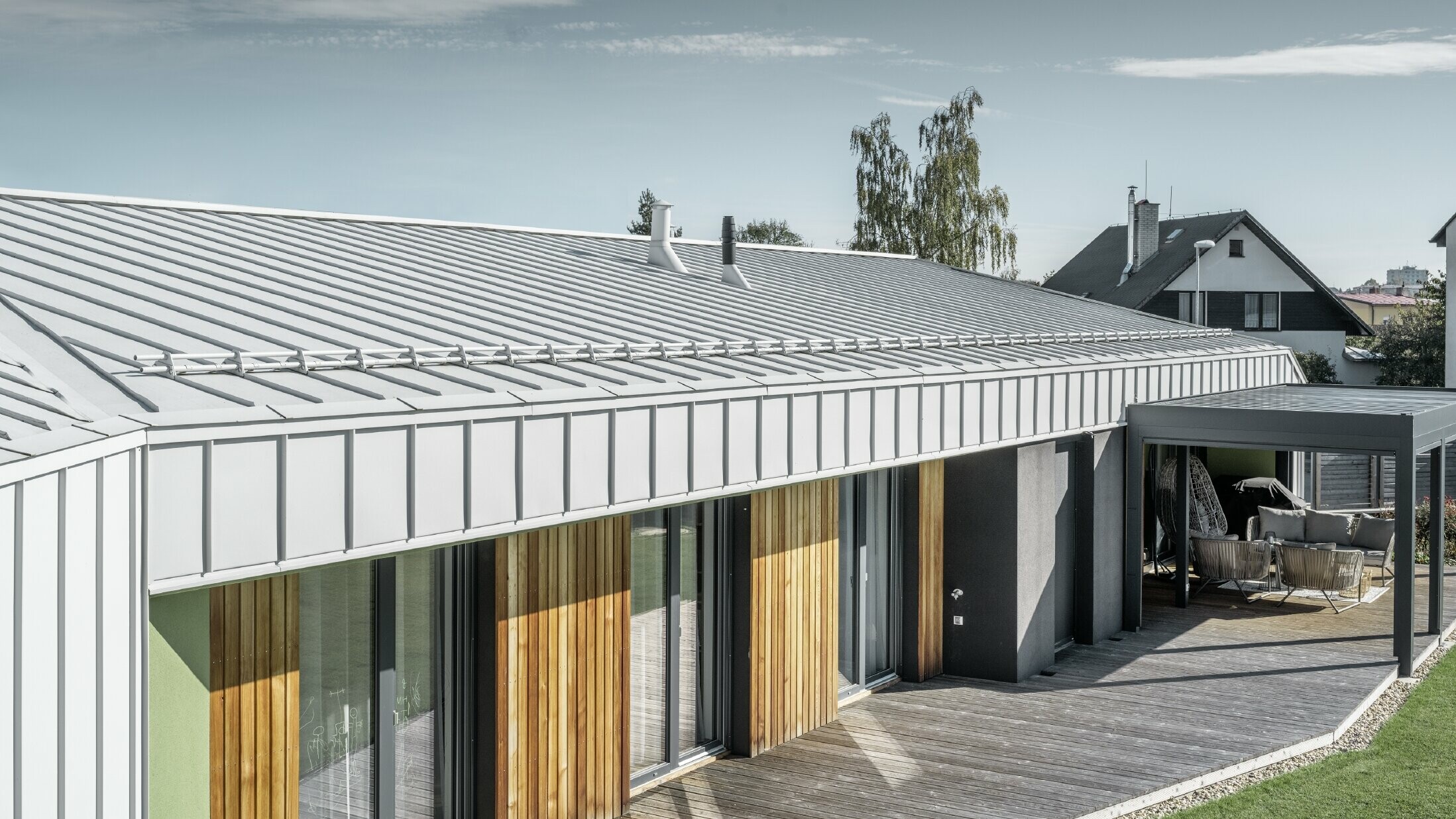 Bungalow med PREFALZ tak og fasade i Prefa-hvitt og med treterrasse