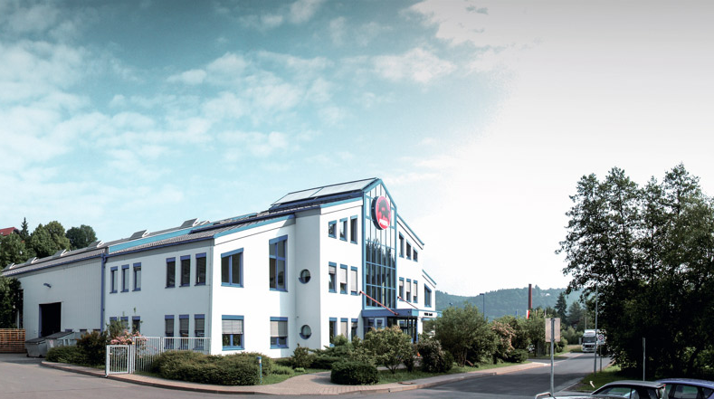 PREFAs firmabygning med blå vinduer og hvit fasade i Wasungen, Tyskland.