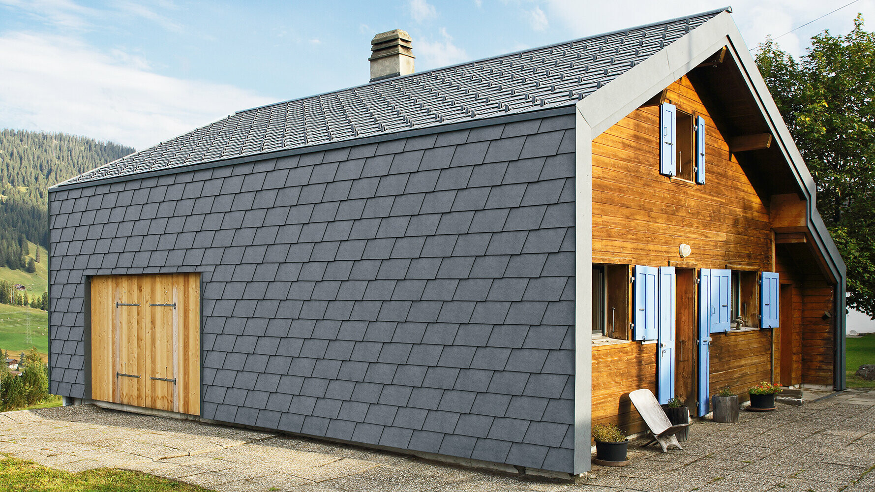 Moderne villa kledd med PREFA fasadeshingel i antrasitt og treelementer.