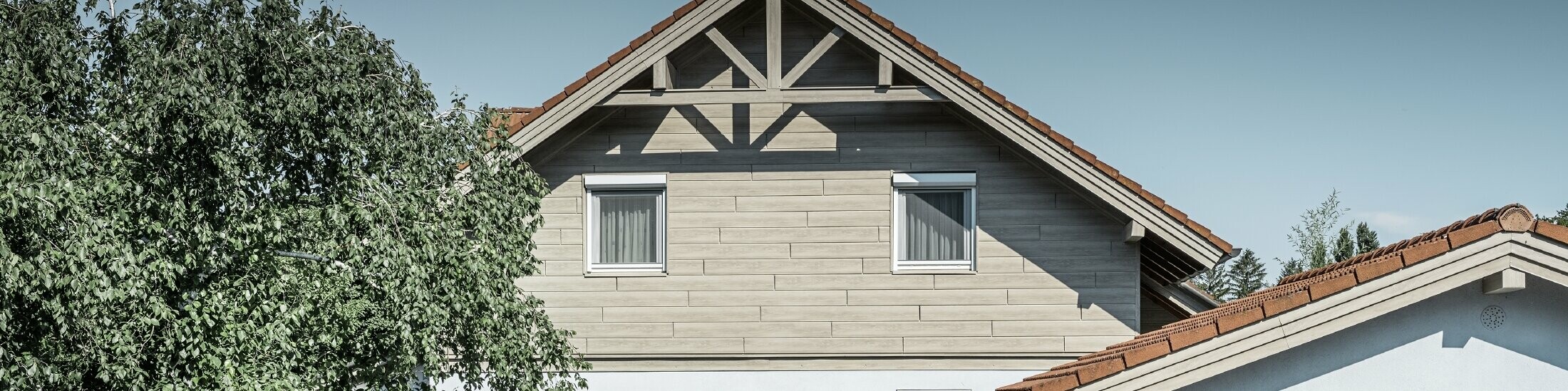 Aluminiumfasaden i trefinish fra PREFA har her blitt lagt horisontalt og trenger aldri å males igjen.