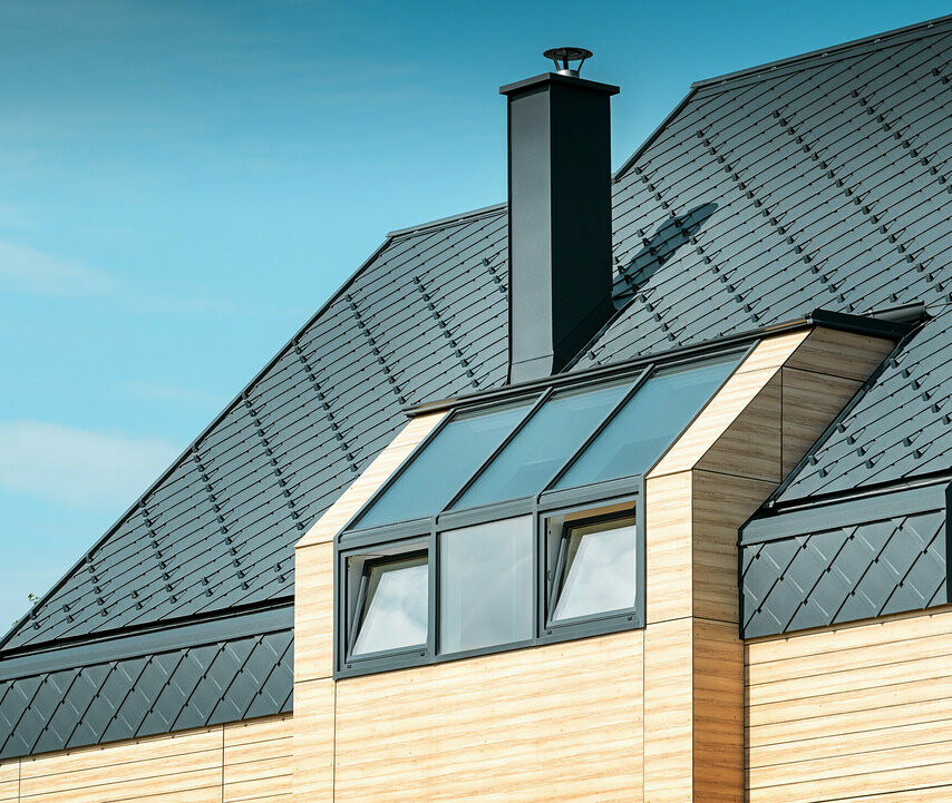 Einfamilienhaus mit Satteldach ohne Dachvorsprung mit einer Fassade in Holzoptik und einem Aluminiumdach in anthrazit